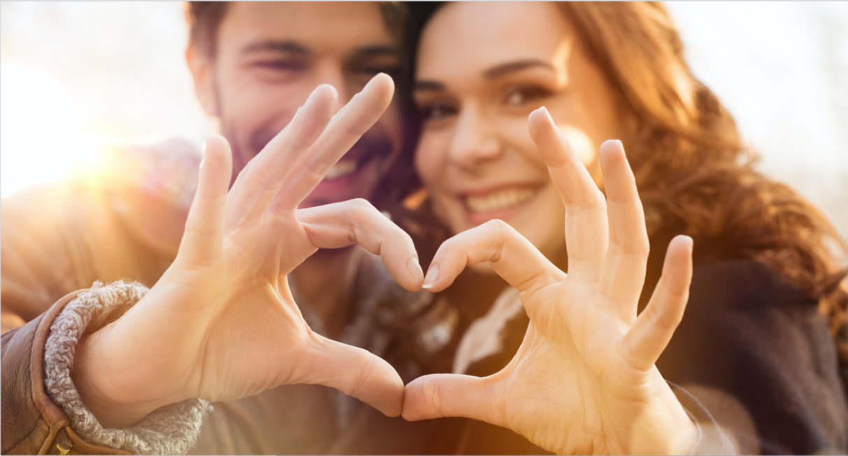 a couple is making a heart hand